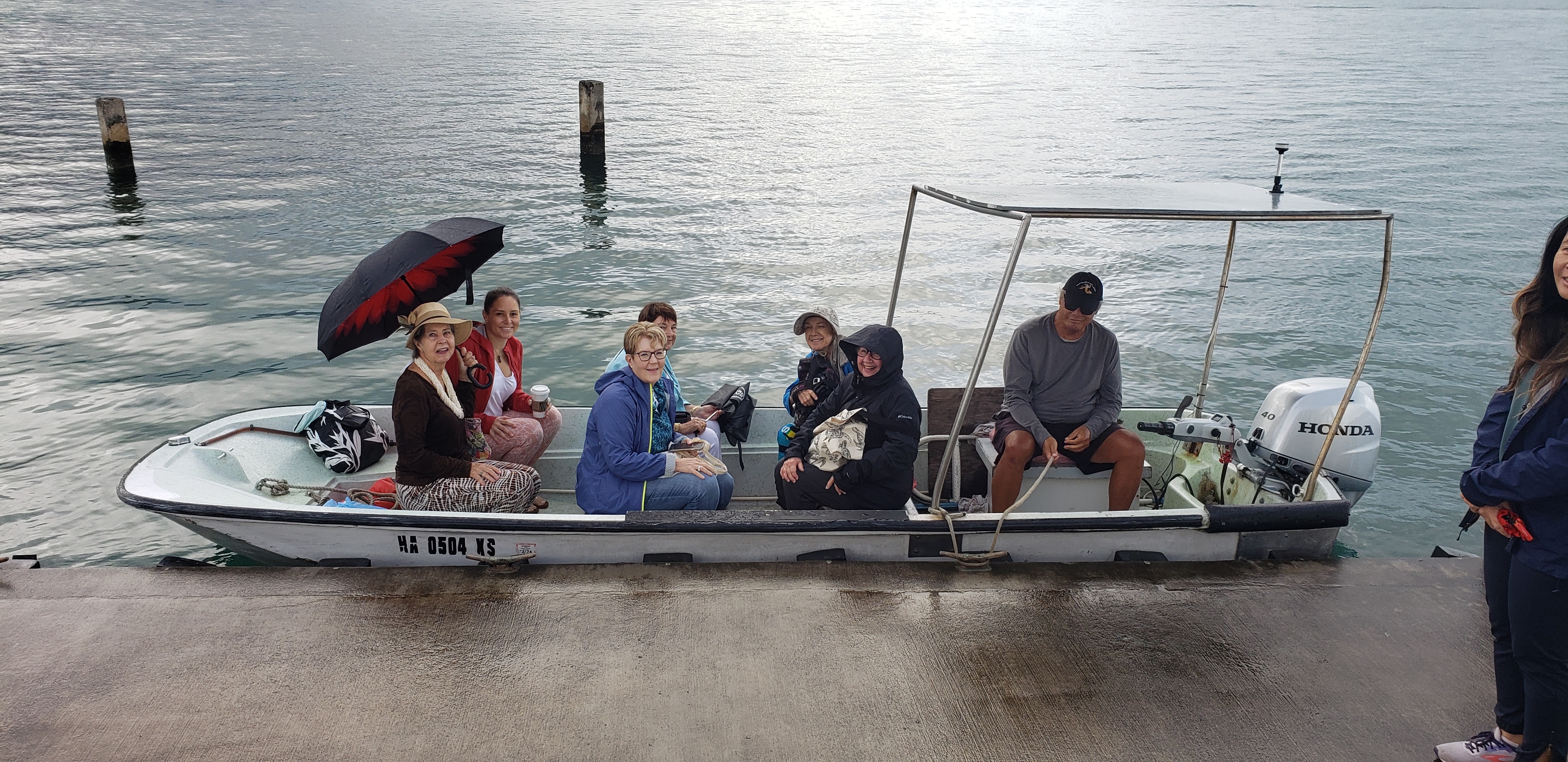 Braving wind and rain Tour participants on outboard motor boat